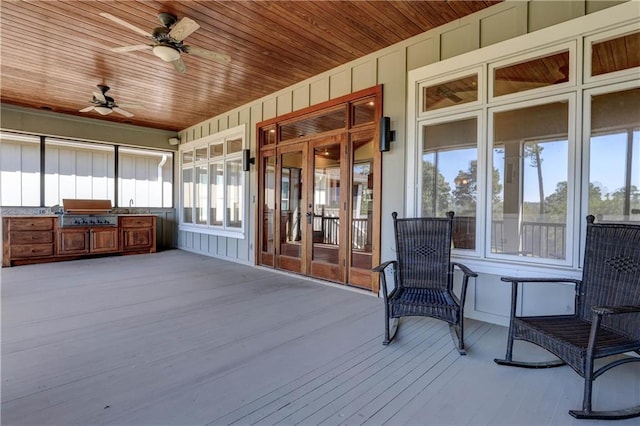 unfurnished sunroom with ceiling fan, wood ceiling, and sink