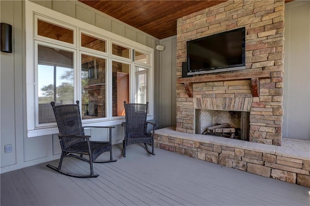 wooden deck with an outdoor stone fireplace