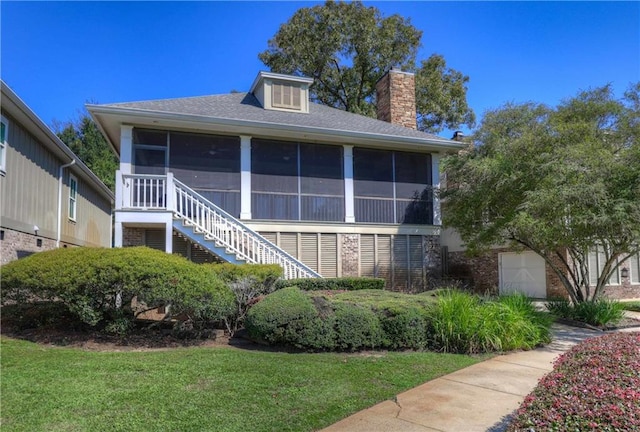 view of front of house featuring a front yard and a sunroom