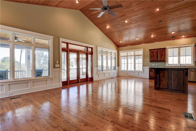 unfurnished living room featuring a wealth of natural light, wood ceiling, and light wood-type flooring