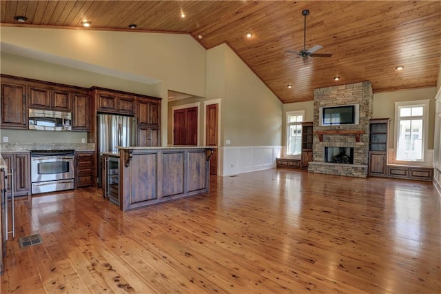 kitchen featuring stainless steel appliances, a breakfast bar, wood ceiling, and light hardwood / wood-style flooring