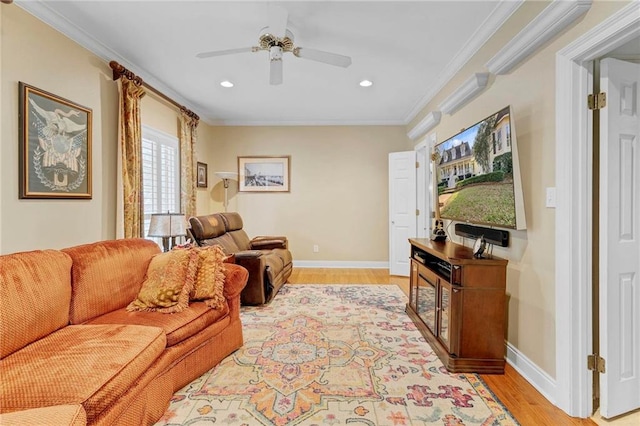 living room featuring ornamental molding, ceiling fan, and light wood-type flooring