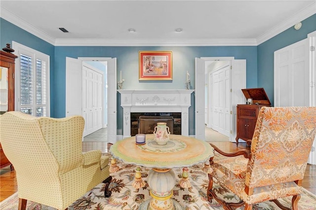 sitting room featuring crown molding and a fireplace