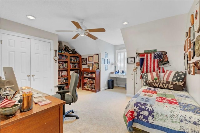 bedroom with light carpet, lofted ceiling, a closet, and ceiling fan