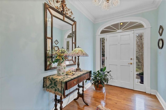 entryway featuring crown molding, an inviting chandelier, and light hardwood / wood-style floors