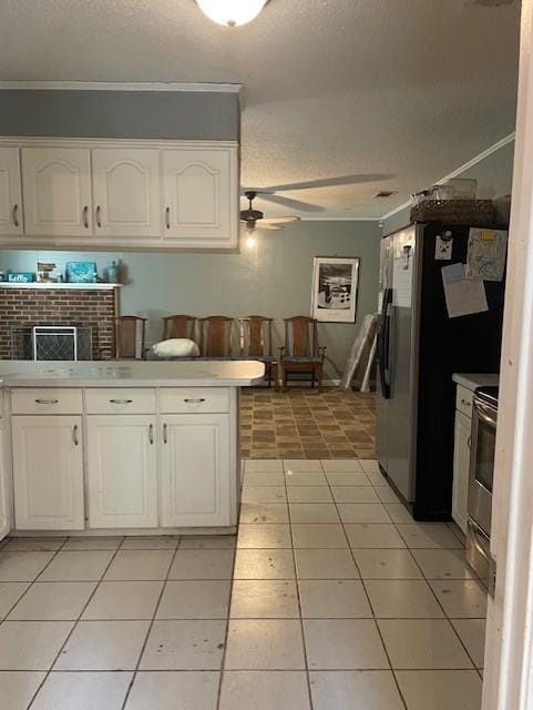 kitchen with a ceiling fan, white cabinetry, appliances with stainless steel finishes, a textured ceiling, and light tile patterned floors