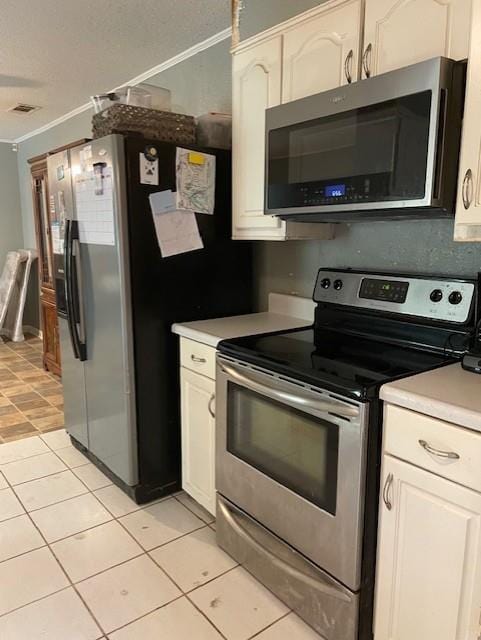 kitchen featuring white cabinetry, light countertops, light tile patterned floors, ornamental molding, and appliances with stainless steel finishes