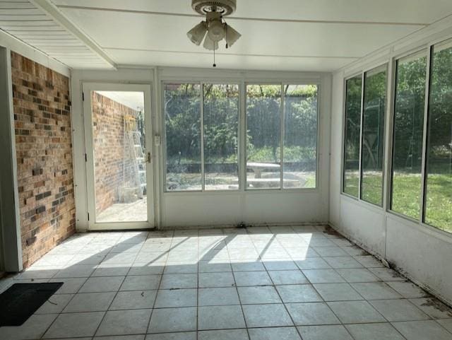 unfurnished sunroom with ceiling fan