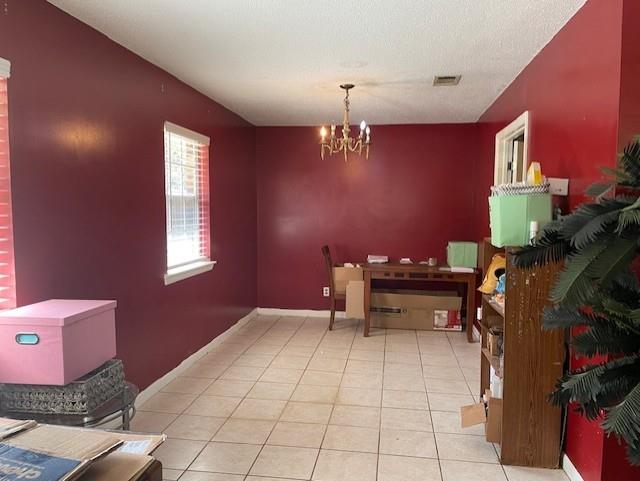dining area featuring tile patterned flooring, a notable chandelier, baseboards, and visible vents