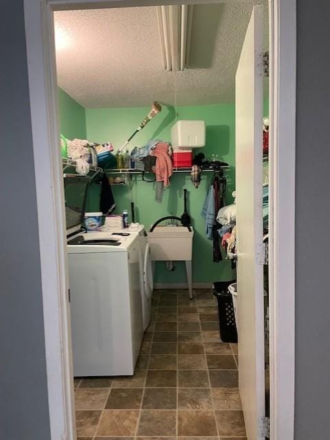 laundry area featuring washer and dryer, laundry area, a sink, and a textured ceiling