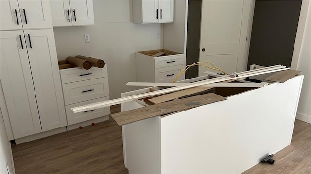 kitchen with a kitchen island, white cabinetry, and wood finished floors