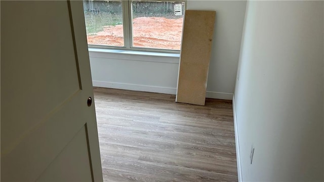 spare room featuring baseboards and wood finished floors