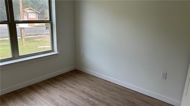 empty room with baseboards and wood finished floors