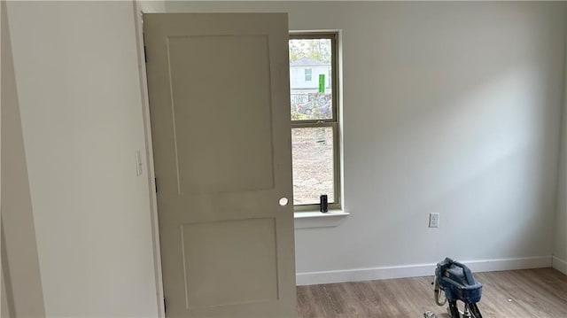 interior space with baseboards and wood finished floors