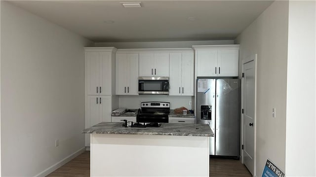 kitchen featuring a center island, white cabinetry, stainless steel appliances, and dark wood-style flooring