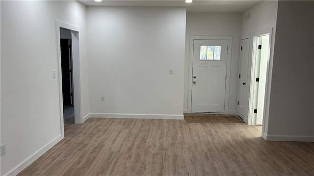 foyer entrance with baseboards and wood finished floors