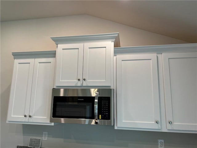 details featuring stainless steel microwave and white cabinets