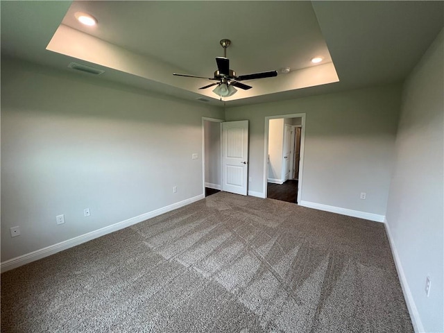 unfurnished bedroom with a tray ceiling, visible vents, baseboards, and recessed lighting