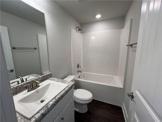 bathroom with toilet, washtub / shower combination, wood finished floors, and vanity