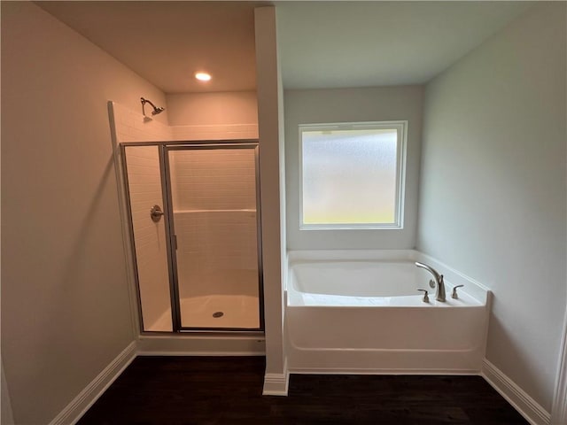 bathroom featuring wood-type flooring and separate shower and tub