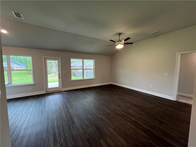 spare room with lofted ceiling, dark wood finished floors, visible vents, and baseboards