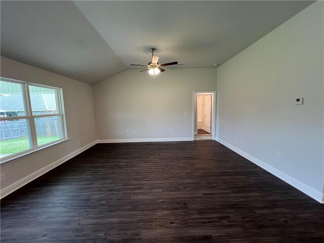 empty room featuring dark hardwood / wood-style flooring, vaulted ceiling, and ceiling fan