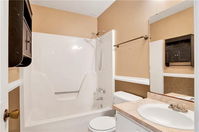 bathroom with shower / washtub combination, a textured ceiling, toilet, and vanity