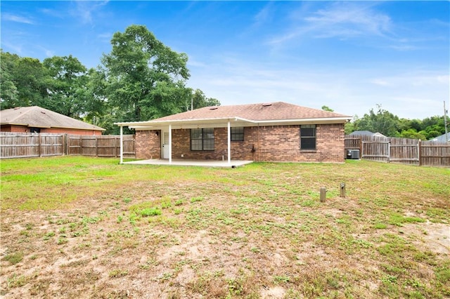 back of house featuring a patio, brick siding, a lawn, and a fenced backyard