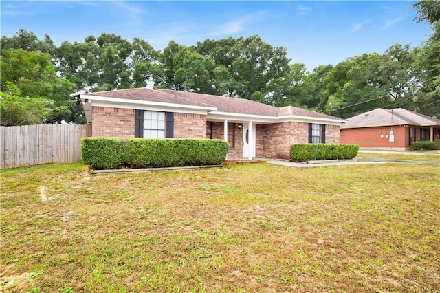 single story home featuring brick siding, a front yard, and fence