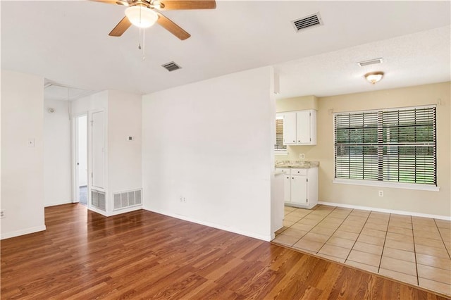 unfurnished room featuring ceiling fan, light wood-type flooring, and visible vents