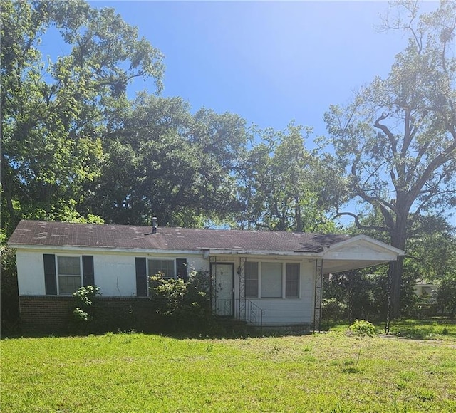 ranch-style house with a carport and a front lawn