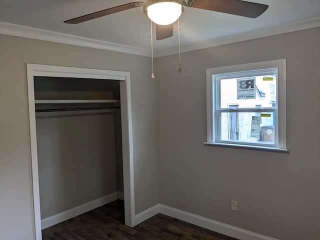 unfurnished bedroom with dark hardwood / wood-style flooring, ornamental molding, ceiling fan, and a closet