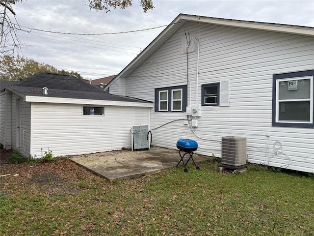 rear view of house featuring a yard, a patio, and central AC