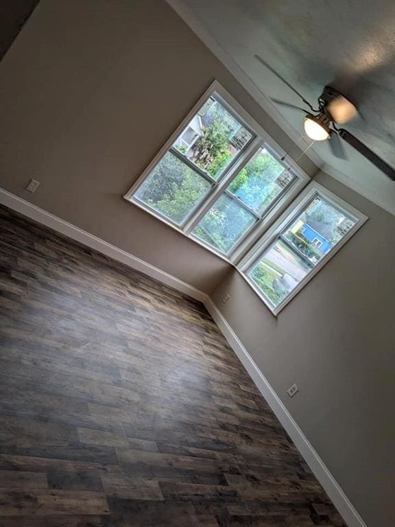 bonus room with ceiling fan and dark wood-type flooring