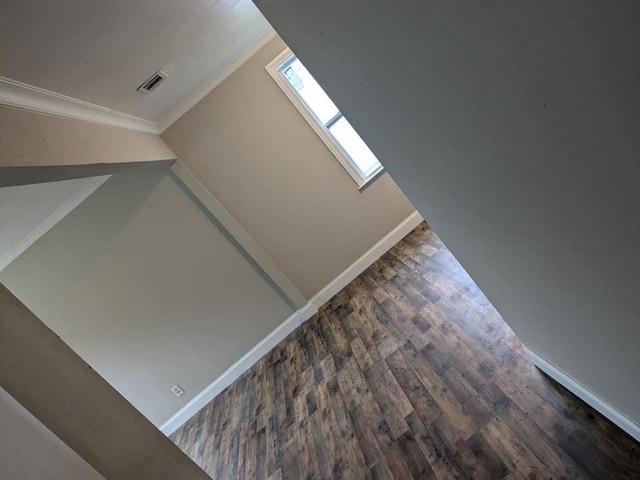 interior details featuring a skylight, hardwood / wood-style flooring, and ornamental molding