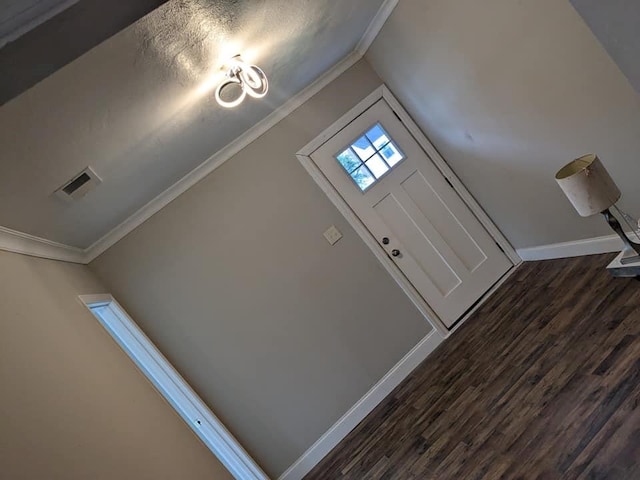 entrance foyer featuring a textured ceiling, crown molding, and dark hardwood / wood-style flooring