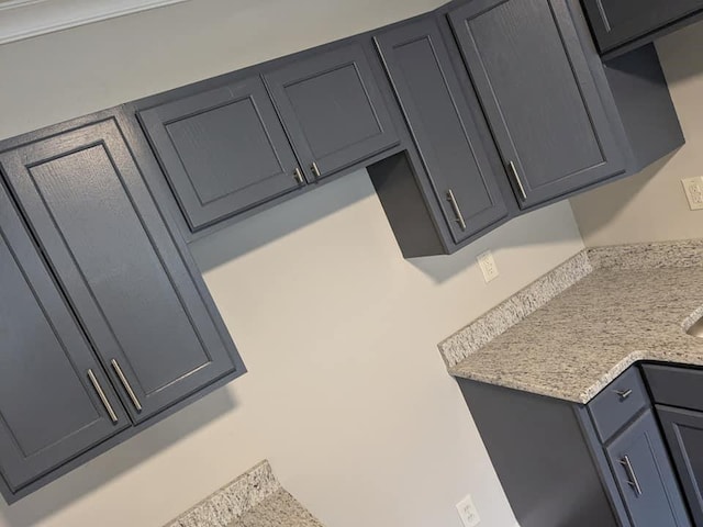 kitchen featuring light stone countertops and gray cabinets