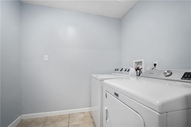 laundry room featuring laundry area, baseboards, washing machine and clothes dryer, and light tile patterned floors