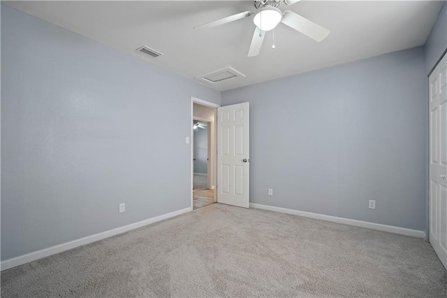 empty room with light carpet, attic access, visible vents, and baseboards