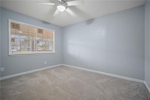 carpeted empty room with ceiling fan and baseboards