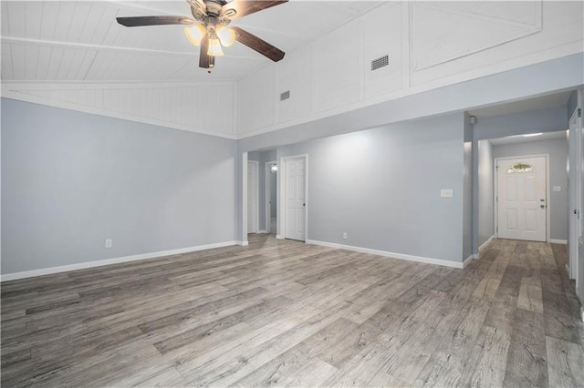 unfurnished room with a ceiling fan, visible vents, baseboards, and wood finished floors