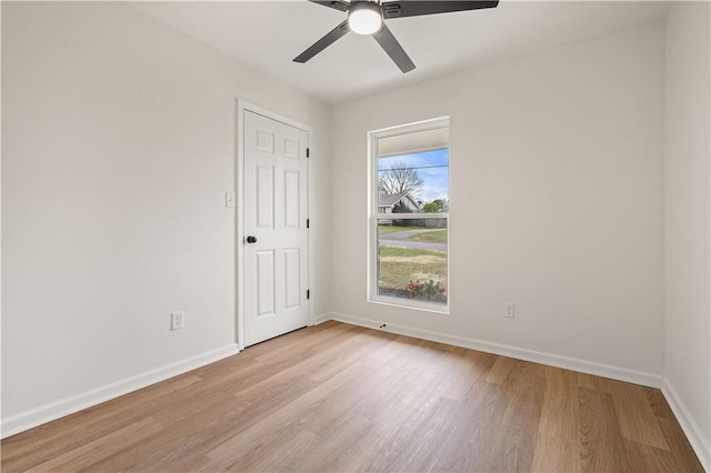 empty room with ceiling fan, baseboards, and light wood-style floors