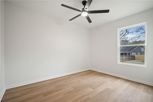 spare room with light wood-type flooring, baseboards, and ceiling fan