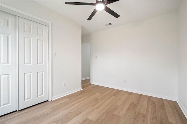 unfurnished bedroom featuring a closet, visible vents, light wood-type flooring, and baseboards