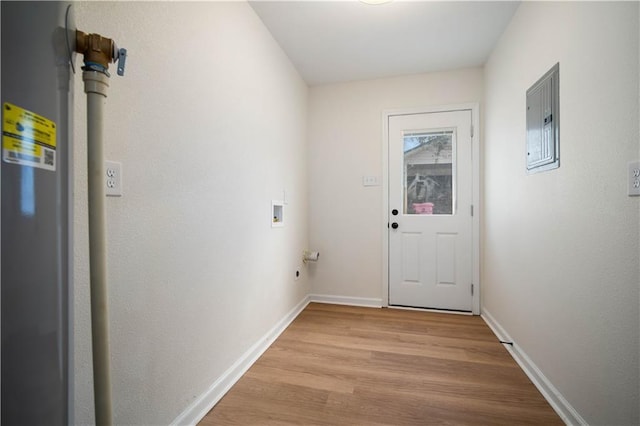 doorway to outside featuring electric panel, light wood-style flooring, and baseboards