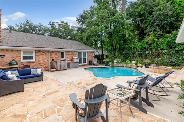 view of pool featuring a patio and an outdoor living space with a fire pit