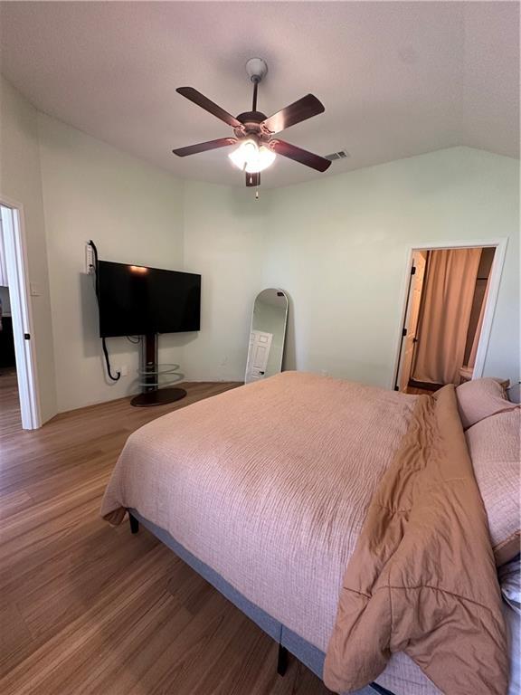 1010 Hamilton Bridges Dr E, Mobile, AL 36695 - bedroom featuring wood finished floors, vaulted ceiling, and ceiling fan