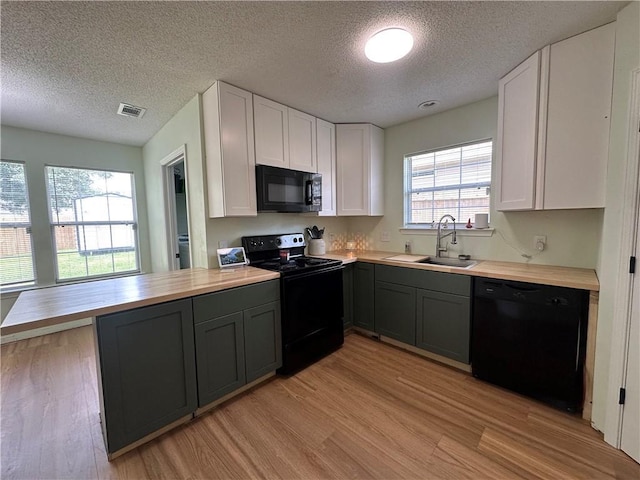 1010 Hamilton Bridges Dr E, Mobile, AL 36695 - kitchen featuring black appliances, a sink, butcher block counters, light wood-style flooring, and white cabinets