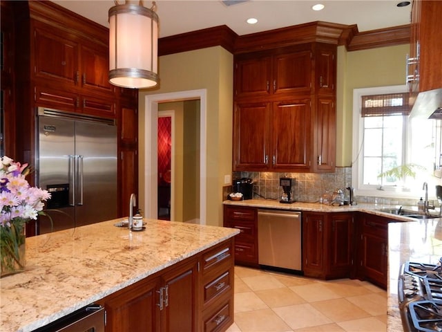 kitchen with light tile floors, light stone countertops, tasteful backsplash, appliances with stainless steel finishes, and sink