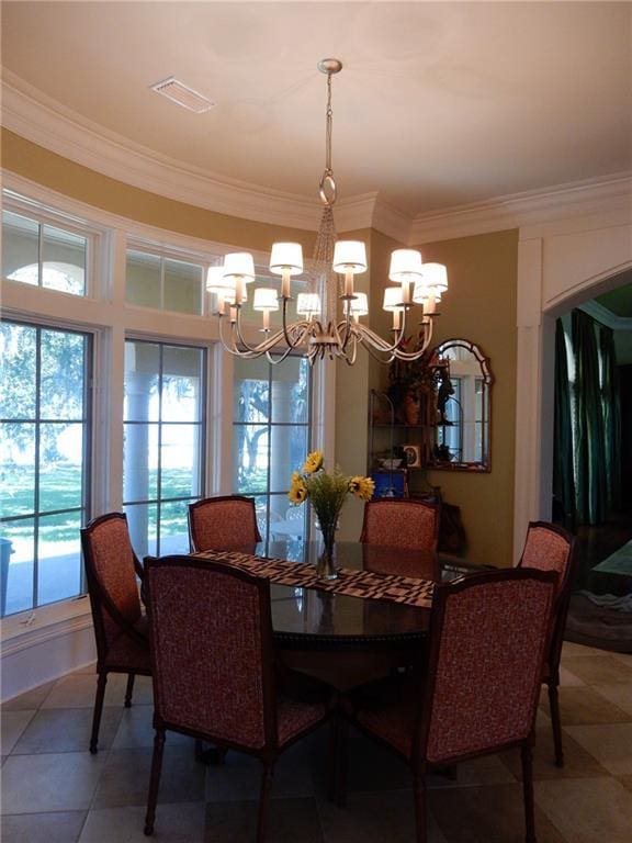 tiled dining space with a chandelier and ornamental molding